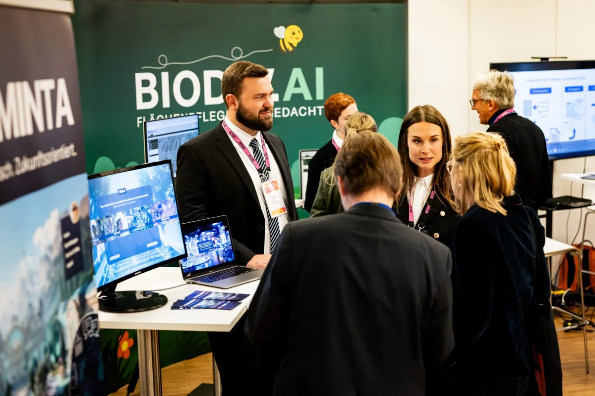 Unveränderte Originalfotografie vom BIODIV.AI Messestand auf der DIGICON 2025, Fachgespräche mit Besuchern